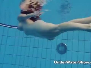 Redheaded cookie swimming nude in the pool
